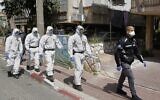 Israeli police officers, dressed in protective outfits, arrive at a yeshiva in the Israeli city of Bnei Brak on April 2, 2020, to ensure that social distancing measures imposed by Israeli authorities meant to curb the spread of the novel coronavirus are being respected. (JACK GUEZ/AFP)
