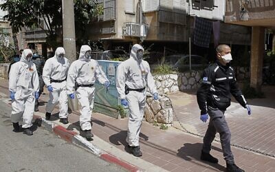 Israeli police officers, dressed in protective outfits, arrive at a yeshiva in the Israeli city of Bnei Brak on April 2, 2020, to ensure that social distancing measures imposed by Israeli authorities meant to curb the spread of the novel coronavirus are being respected. (JACK GUEZ/AFP)