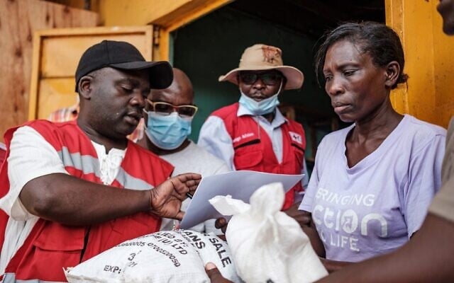 Red Cross volunteers register people during the first day of the government's food distribution for people who have been affected by the lockdown in Kampala, Uganda, on April 4, 2020. (SUMY SADURNI/AFP) Red Cross volunteers register people during the first day of the government's food distribution for people who have been affected by the lockdown in Kampala, Uganda, on April 4, 2020. (SUMY SADURNI/AFP)