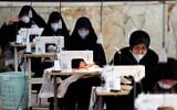 Iranian women, members of paramilitary Basij organization, make face masks and other protective items at a mosque in the capital Tehran, amid the novel coronavirus pandemic crisis on April 5, 2020. (ATTA KENARE/AFP)