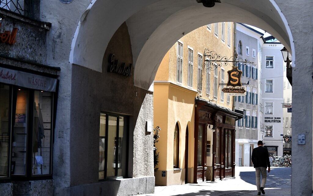 A man walks along an empty street in the old town area of Salzburg on April 6, 2020 during the exit restrictions amid the new coronavirus / Covid-19 pandemic. (BARBARA GINDL / APA / AFP)