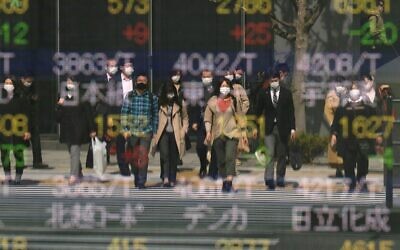 Pedestrians are reflected in a quotation board of the Tokyo Stock Exchange in Tokyo on April 8, 2020. (Kazuhiro NOGI / AFP)