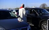Pastor Frank Heidkamp talks to a visitor in a car during an easter service under the open sky in Duesseldorf drive-in cinema, western Germany, on April 10, 2020, amidst the new coronavirus COVID-19 pandemic. (Ina FASSBENDER / AFP)