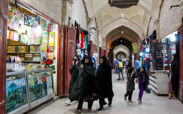 Iranians, some wearing personal protective equipment, walk past shops in the southeastern city of Kerman on April 11, 2020, amid the coronavirus (COVID-19) pandemic. (ISNA / AFP) Iranians, some wearing personal protective equipment, walk past shops in the southeastern city of Kerman on April 11, 2020, amid the coronavirus (COVID-19) pandemic. (ISNA / AFP)