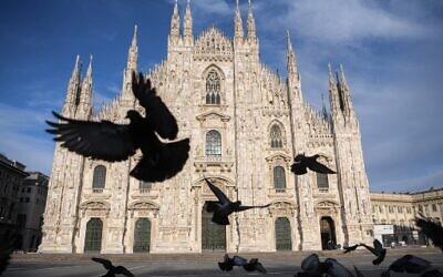 Pigeons fly over a deserted Piazza del Duomo in central Milan on April 12, 2020, during the country's lockdown aimed at curbing the spread of the COVID-19 infection. (Piero CRUCIATTI/AFP)