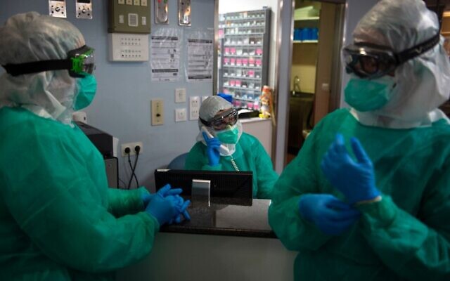 Healthcare workers in full protective gear chat before attending to COVID-19 coronavirus patients at the Intensive Unit Care of the Povisa Hospital in Vigo, northwestern Spain, on April 16, 2020. (Photo by MIGUEL RIOPA / AFP) Healthcare workers in full protective gear chat before attending to COVID-19 coronavirus patients at the Intensive Unit Care of the Povisa Hospital in Vigo, northwestern Spain, on April 16, 2020. (Photo by MIGUEL RIOPA / AFP)