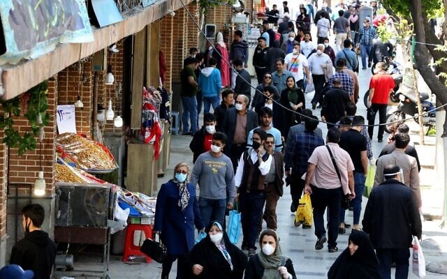 Iranians, some wearing protective gear amid the COVID-19 pandemic, shop on a street by the Grand Bazaar market in the capital Tehran, on April 18, 2020 (ATTA KENARE / AFP) Iranians, some wearing protective gear amid the COVID-19 pandemic, shop on a street by the Grand Bazaar market in the capital Tehran, on April 18, 2020 (ATTA KENARE / AFP)