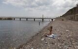 A woman sits along the empty Red Sea shore in the southern resort city of Eilat on April 17, 2020, amid the coronavirus pandemic. (Menahem Kahana/AFP)