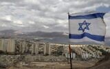 An Israeli flag flutters as the Red Sea resort city of Eilat and Jordan's Red Sea resort city of Aqaba are seen in the background, on April 17, 2020. (Menahem Kahana/AFP)