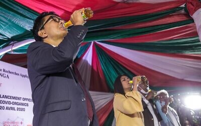 Madagascar's President Andry Rajoelina drinks a sample of the "Covid Organics" or CVO remedy at a launch ceremony in Antananarivo on April 20, 2020. "Covid Organics" or CVO is a remedy produced by the Malagasy Institute of Applied Research (IMRA) created from the Artemisia plant and is claimed to help prevent coronavirus Covid-19 infection. (RIJASOLO / AFP)