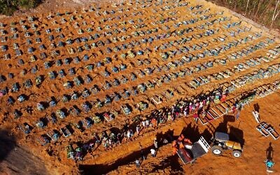 Illustrative: Aerial view of cemetery workers unloading a coffin from a truck at an area where new graves have been dug at the Parque Taruma cemetery, during the COVID-19 coronavirus pandemic in Manaus, Amazonas state, Brazil, on April 21, 2020. (MICHAEL DANTAS / AFP)
