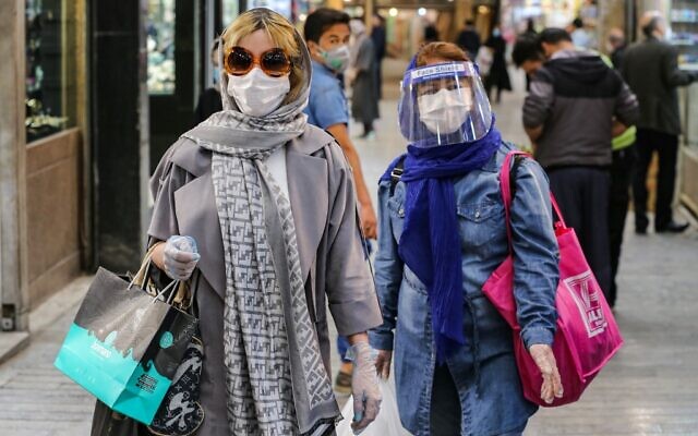 Shoppers clad in protective gear, including face masks and shields and latex gloves, due to the coronavirus pandemic, walk through the Tajrish Bazaar in Iran's capital Tehran, April 25, 2020. (ATTA KENARE / AFP) Shoppers clad in protective gear, including face masks and shields and latex gloves, due to the coronavirus pandemic, walk through the Tajrish Bazaar in Iran's capital Tehran, April 25, 2020. (ATTA KENARE / AFP)