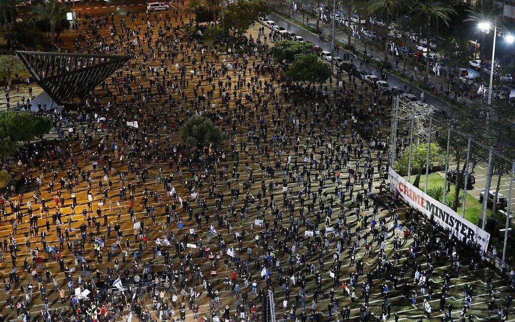 Israelis wearing protective masks and dressed mainly in black take part in a demonstration on April 25, 2020, in Rabin Square in Tel Aviv, to protest what they consider threats to Israeli democracy, against the backdrop of an imminent coalition between Prime Minister Benjamin Netanyahu and his ex-rival Benny Gantz. The protesters stood two meters apart from each other, thereby respecting the social distancing measures in force to fight the COVID-19 pandemic. (JACK GUEZ / AFP)
