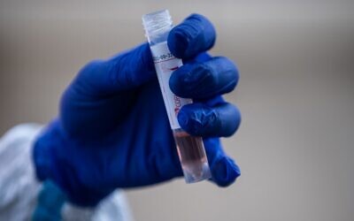 A doctor holds a container used to collect a sample from a patient during a demonstration of a drive-through polymerase chain reaction (PCR) swab test for the COVID-19 coronavirus in Fujisawa in Kanagawa prefecture, southwest of Tokyo, Japan, on April 27, 2020. (Philip Fong/AFP) A doctor holds a container used to collect a sample from a patient during a demonstration of a drive-through polymerase chain reaction (PCR) swab test for the COVID-19 coronavirus in Fujisawa in Kanagawa prefecture, southwest of Tokyo, Japan, on April 27, 2020. (Philip Fong/AFP)