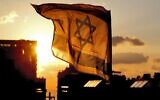 An Israeli flag is seen flying at sunset in the coastal city of Netanya on April 29, 2020, during Israel's 72nd Independence Day. (Jack Guez/AFP)