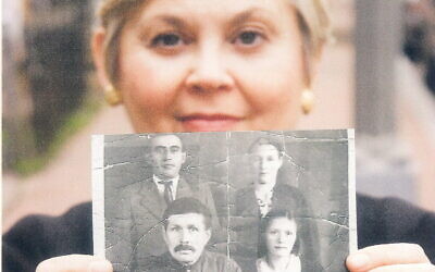 Esther Safran Foer holds a black and white photo of her father, Louis, top left, and the family that hid him during the war. (Courtesy)