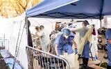 Medical workers putting on protective gear at the beginning of their shift at the emergency field hospital run by Samaritan's Purse and Mount Sinai Health System in Central Park on April 8, 2020 in New York. (Misha Friedman/Getty Images/AFP)