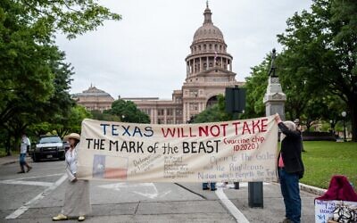 Protesters hold up a sign in front of the Texas State Capitol building on April 18, 2020 in Austin, Texas.  (Sergio Flores/Getty Images/AFP)
