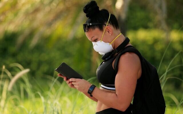 A woman wearing a mask checks her phone on April 02, 2020 in Miami Beach, Florida. Florida Gov. Ron DeSantis signed a "Stay-at-Home" order Wednesday in response to the coronavirus (COVID-19) pandemic. (Cliff Hawkins/Getty Images/AFP) A woman wearing a mask checks her phone on April 02, 2020 in Miami Beach, Florida. Florida Gov. Ron DeSantis signed a "Stay-at-Home" order Wednesday in response to the coronavirus (COVID-19) pandemic. (Cliff Hawkins/Getty Images/AFP)