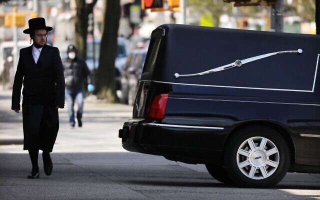 A man walks by a funeral home and hearse in the heavily Orthodox Borough Park neighborhood of Brooklyn on April 16, 2020 in New York City. (Spencer Platt/Getty Images/AFP) A man walks by a funeral home and hearse in the heavily Orthodox Borough Park neighborhood of Brooklyn on April 16, 2020 in New York City. (Spencer Platt/Getty Images/AFP)