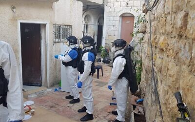 Israel Police wearing protective clothing seen in the Mea Shearim neighborhood of Jerusalem to arrest a man diagnosed with the coronavirus who broke quarantine orders April 6, 2020. (Israel Police)