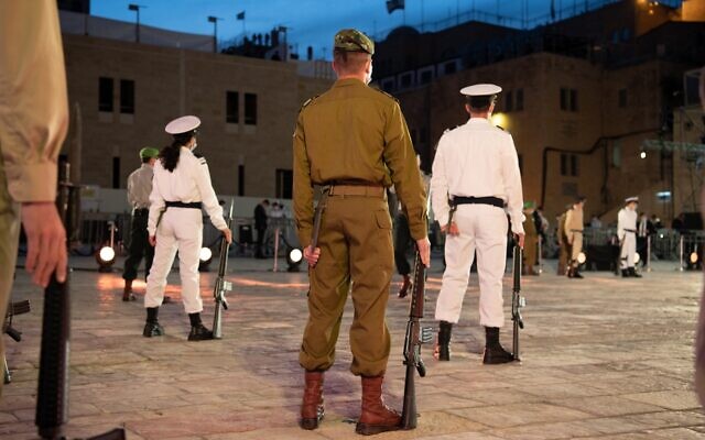 Soldiers wearing masks stand at attention at the national opening ceremony for Israel's Memorial Day for fallen soldiers and victims of terror, at the Western Wall in Jerusalem, April 27, 2020 (Amos Ben Gershom / GPO)