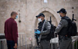 Israel Border Police officers speak with a man at the Damascus Gate in Jerusalem’s Old City during the first day of Ramadan, April 24, 2020. (Yonatan Sindel/Flash90/ via JTA)