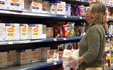 A woman wears a mask while shopping for Passover items at a grocery store in Overland Park, Kan., April 7, 2020. (Jamie Squire/Getty Images via JTA)