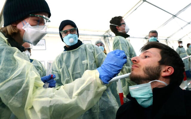 German medical employees demonstrate testing at a coronavirus test center for public service employees, during a media presentation in Munich, Germany, March 23, 2020. (AP Photo/Matthias Schrader, File) German medical employees demonstrate testing at a coronavirus test center for public service employees, during a media presentation in Munich, Germany, March 23, 2020. (AP Photo/Matthias Schrader, File)