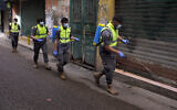 Islamic Health Society, an arm of the Iran-backed Hezbollah terror group spray disinfectant as a precaution against the coronavirus, in a southern suburb of Beirut, Lebanon, March 27, 2020. (Bilal Hussein/AP)