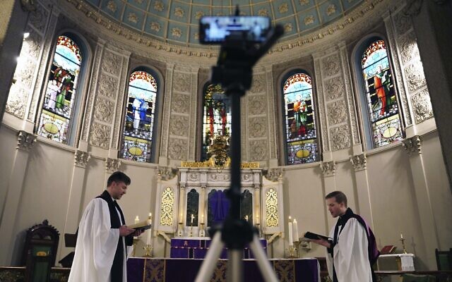 The Rev. Steven Paulikas, right, and curate Spencer Cantrell deliver an Evening Prayer service over Facebook Live in the Brooklyn borough of New York, March 29, 2020. (AP Photo/Emily Leshner) The Rev. Steven Paulikas, right, and curate Spencer Cantrell deliver an Evening Prayer service over Facebook Live in the Brooklyn borough of New York, March 29, 2020. (AP Photo/Emily Leshner)