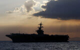 In this April 13, 2018, file photo the USS Theodore Roosevelt aircraft carrier is anchored off Manila Bay west of Manila, Philippines. The captain of the US Navy aircraft carrier facing a growing outbreak of the coronavirus is asking for permission to isolate the bulk of his roughly 5,000 crew members on shore, which would take the warship out of duty in an effort to save lives. The ship is docked in Guam (AP Photo/Bullit Marquez, File)