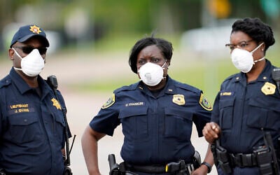 Law enforcement officers wear masks while working at a newly opened free drive through Covid-19 testing site provided by United Memorial Medical Center Thursday, April 2, 2020, in Houston. (AP Photo/David J. Phillip)