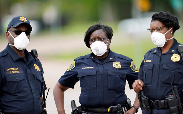 Law enforcement officers wear masks while working at a newly opened free drive through Covid-19 testing site provided by United Memorial Medical Center Thursday, April 2, 2020, in Houston. (AP Photo/David J. Phillip) Law enforcement officers wear masks while working at a newly opened free drive through Covid-19 testing site provided by United Memorial Medical Center Thursday, April 2, 2020, in Houston. (AP Photo/David J. Phillip)