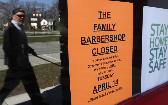 A pedestrian walks by The Family Barbershop, closed due to a Gov. Gretchen Whitmer executive order, in Grosse Pointe Woods, Michigan on April 2, 2020. (AP Photo/Paul Sancya) A pedestrian walks by The Family Barbershop, closed due to a Gov. Gretchen Whitmer executive order, in Grosse Pointe Woods, Michigan on April 2, 2020. (AP Photo/Paul Sancya)
