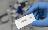A scientist presents an antibody test for coronavirus in a laboratory of the Leibniz Institute of Photonic Technology (Leibniz IPHT) at the InfectoGnostics research campus in Jena, Germany, April 3, 2020. (AP/Jens Meyer)
