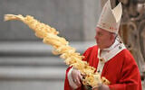 Pope Francis holds a palm branch as he celebrates Palm Sunday Mass behind closed doors in St. Peter's Basilica, at the Vatican, Sunday, April 5, 2020, during the lockdown aimed at curbing the spread of the COVID-19 infection, caused by the novel coronavirus. (AP Photo/pool/Alberto Pizzoli)
