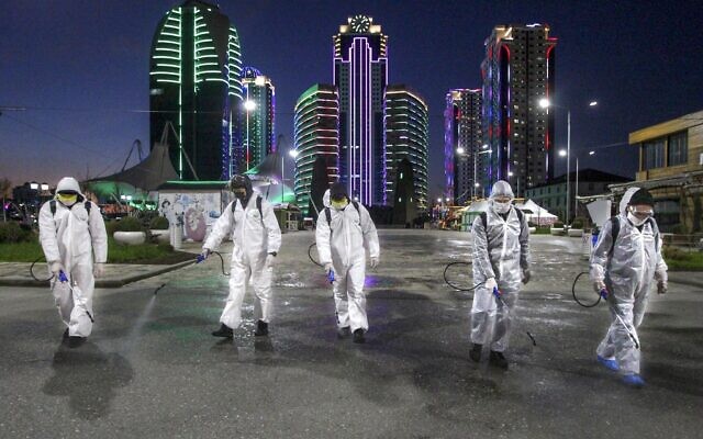 Municipal workers wearing protective suits spray disinfectant in an area in the center of Grozny, Russia, Monday, April 6, 2020. Ramzan Kadyrov, strongman leader of Russia's province of Chechnya, has taken extreme measures to fight the spread of the new coronavirus in the region, vowing Monday not to let anyone who is not a formal resident of Chechnya into the area. (AP Photo/Musa Sadulayev) Municipal workers wearing protective suits spray disinfectant in an area in the center of Grozny, Russia, Monday, April 6, 2020. Ramzan Kadyrov, strongman leader of Russia's province of Chechnya, has taken extreme measures to fight the spread of the new coronavirus in the region, vowing Monday not to let anyone who is not a formal resident of Chechnya into the area. (AP Photo/Musa Sadulayev)