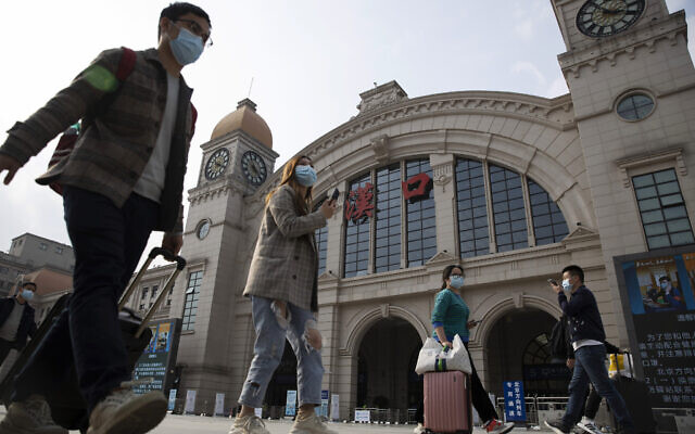 Travelers with their luggage walk past the Hankou railway station on the eve of its resuming outbound traffic in Wuhan in central China's Hubei province on April 7, 2020. (AP Photo/Ng Han Guan) Travelers with their luggage walk past the Hankou railway station on the eve of its resuming outbound traffic in Wuhan in central China's Hubei province on April 7, 2020. (AP Photo/Ng Han Guan)