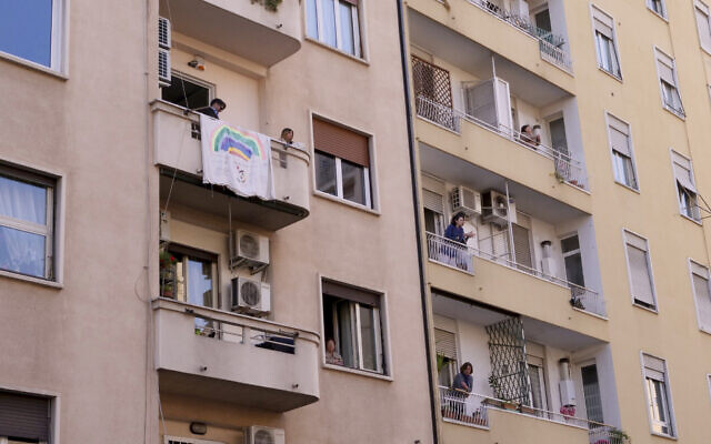 People stand on their balconies to listen to an Easter Mass delivered from the roof of a church, in Rome, April 12, 2020. (Luigi Navarra/AP) People stand on their balconies to listen to an Easter Mass delivered from the roof of a church, in Rome, April 12, 2020. (Luigi Navarra/AP)