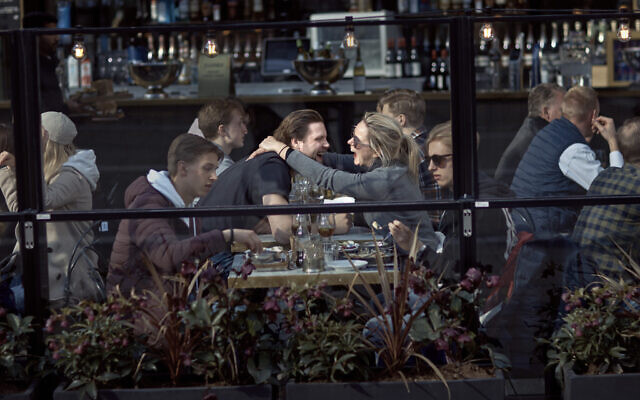 A couple hug and laugh as they have lunch in a restaurant in Stockholm, Sweden, April 4, 2020. (AP Photo/Andres Kudacki, File) A couple hug and laugh as they have lunch in a restaurant in Stockholm, Sweden, April 4, 2020. (AP Photo/Andres Kudacki, File)
