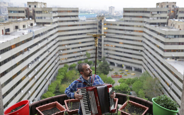 In this April 8, 2020, photo, Behnam Emran, a 28-year-old self-taught musician, plays accordion on the roof of his home during mandatory self-isolation due to the new coronavirus disease outbreak, in Tehran, Iran. (AP Photo/Ebrahim Noroozi) In this April 8, 2020, photo, Behnam Emran, a 28-year-old self-taught musician, plays accordion on the roof of his home during mandatory self-isolation due to the new coronavirus disease outbreak, in Tehran, Iran. (AP Photo/Ebrahim Noroozi)
