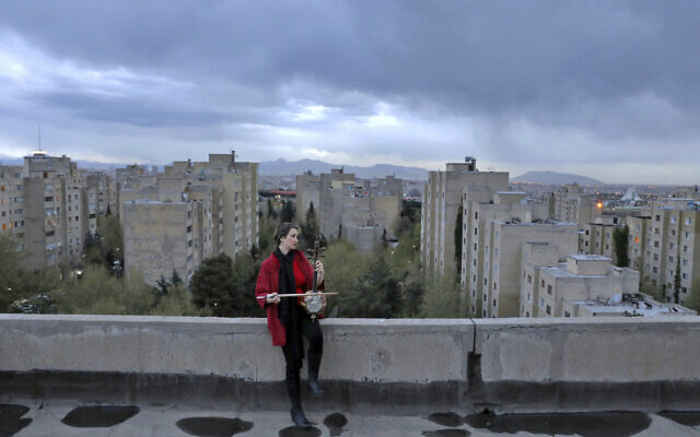 In this March 30, 2020, photo, musician Shiva Abedi, 30, plays kamancheh on the roof of her home during mandatory self-isolation due to the new coronavirus disease outbreak, in Tehran, Iran. (AP Photo/Ebrahim Noroozi) In this March 30, 2020, photo, musician Shiva Abedi, 30, plays kamancheh on the roof of her home during mandatory self-isolation due to the new coronavirus disease outbreak, in Tehran, Iran. (AP Photo/Ebrahim Noroozi)
