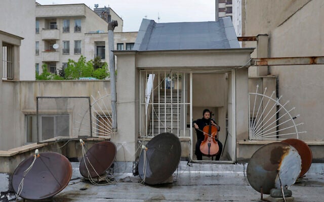 In this April 9, 2020 photo, musician Yasamin Koozehgar, 22, plays cello on the roof of her home during mandatory self-isolation due to the new coronavirus disease outbreak, in Tehran, Iran. (AP Photo/Ebrahim Noroozi) In this April 9, 2020 photo, musician Yasamin Koozehgar, 22, plays cello on the roof of her home during mandatory self-isolation due to the new coronavirus disease outbreak, in Tehran, Iran. (AP Photo/Ebrahim Noroozi)