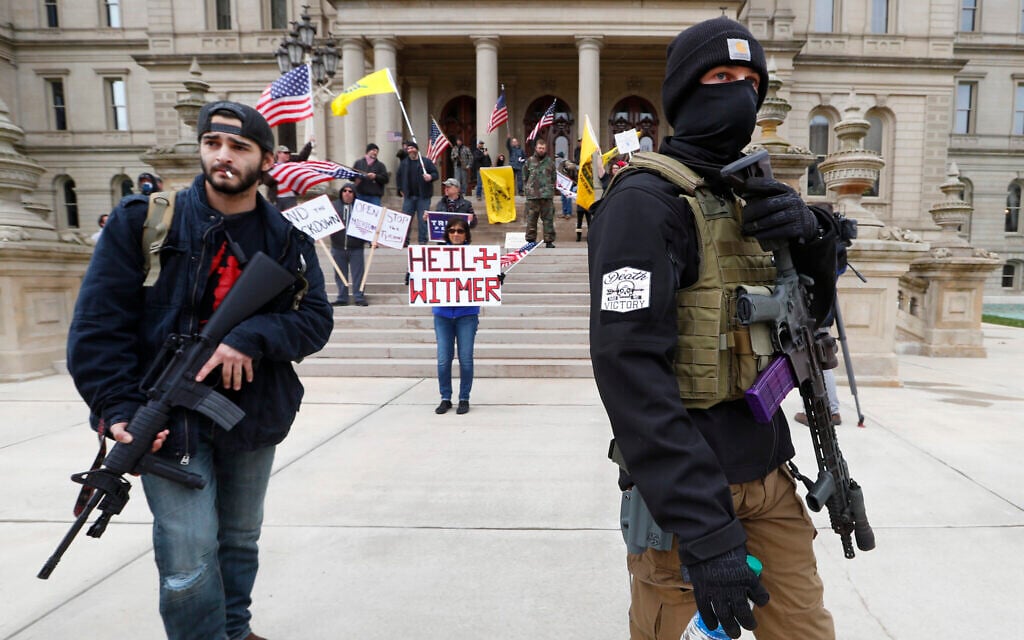 Protesters carry rifles near the steps of the Michigan State Capitol building in Lansing, Michigan, April 15, 2020. (AP Photo/Paul Sancya) Protesters carry rifles near the steps of the Michigan State Capitol building in Lansing, Michigan, April 15, 2020. (AP Photo/Paul Sancya)