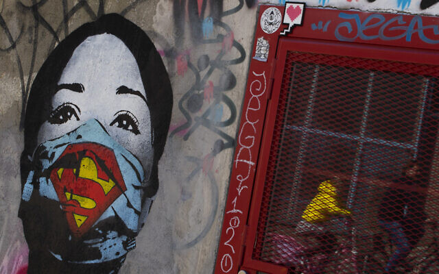 A mother and her child are reflected as they pass a mural by artist FAKE, titled "Super Nurse", paying tribute to all healthcare and medical professionals in times of the coronavirus, in Amsterdam, Netherlands, Sunday, April 19, 2020. (AP Photo/Peter Dejong) A mother and her child are reflected as they pass a mural by artist FAKE, titled "Super Nurse", paying tribute to all healthcare and medical professionals in times of the coronavirus, in Amsterdam, Netherlands, Sunday, April 19, 2020. (AP Photo/Peter Dejong)