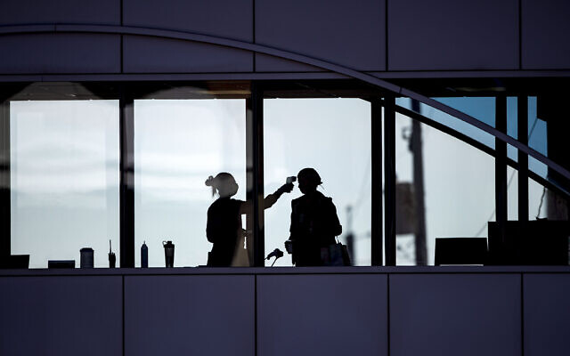 In this April 10, 2020, file photo, amid coronavirus concerns, a US healthcare worker takes the temperature of a visitor to Essentia Health who was crossing over a skywalk bridge from the adjoining parking deck, in Duluth, Minnesota. (Alex Kormann/Star Tribune via AP, File) In this April 10, 2020, file photo, amid coronavirus concerns, a US healthcare worker takes the temperature of a visitor to Essentia Health who was crossing over a skywalk bridge from the adjoining parking deck, in Duluth, Minnesota. (Alex Kormann/Star Tribune via AP, File)