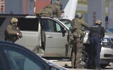 Royal Canadian Mounted Police officers confront the suspect of a shooting rampage at a gas station in Enfield, Nova Scotia on Sunday April 19, 2020.  (Tim Krochak/The Canadian Press via AP)
