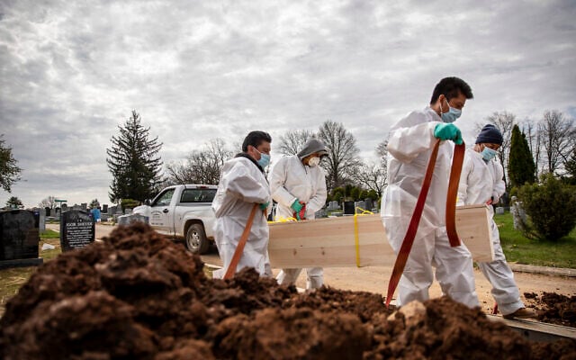 US gravediggers carry the casket of someone presumed to have died from coronavirus as they are buried without any family present at Mount Richmond Cemetery in the Staten Island borough of New York, April 7, 2020. (AP Photo/David Goldman) US gravediggers carry the casket of someone presumed to have died from coronavirus as they are buried without any family present at Mount Richmond Cemetery in the Staten Island borough of New York, April 7, 2020. (AP Photo/David Goldman)