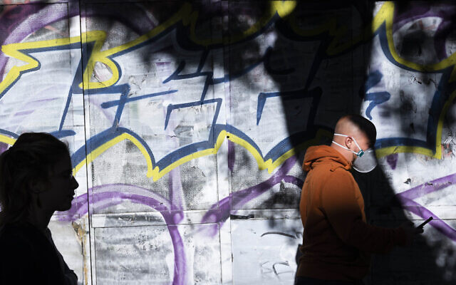 In this March 25, 2020, photo, a man wears a protective face mask amid concerns over the country's coronavirus outbreak in Tel Aviv, Israel. (AP Photo/Oded Balilty)